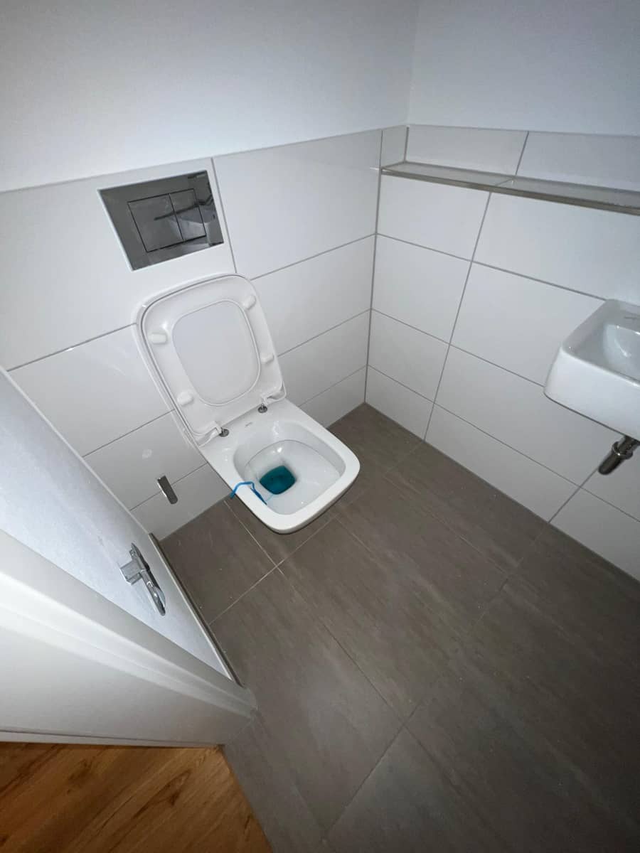Fertig renoviertes Gäste-WC mit wandhängendem WC und Waschtisch