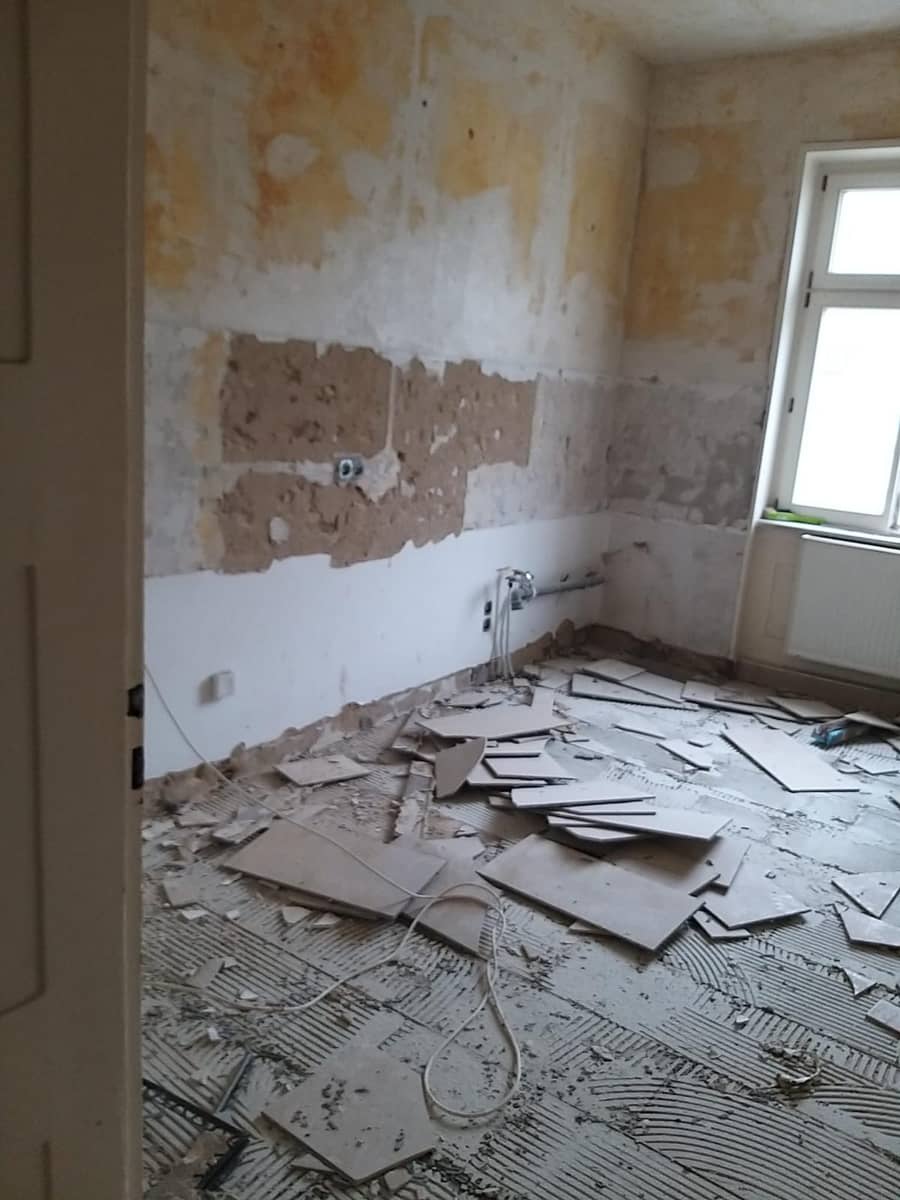 Raum nach dem Rückbau mit freigelegtem Untergrund und Bauschutt